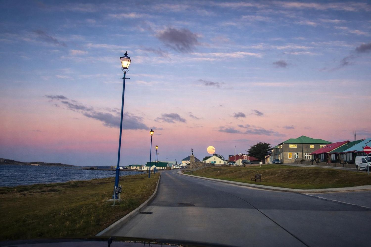Ross Road, Stanley, Falkland Islands, at dusk with the moon rising over the harbour